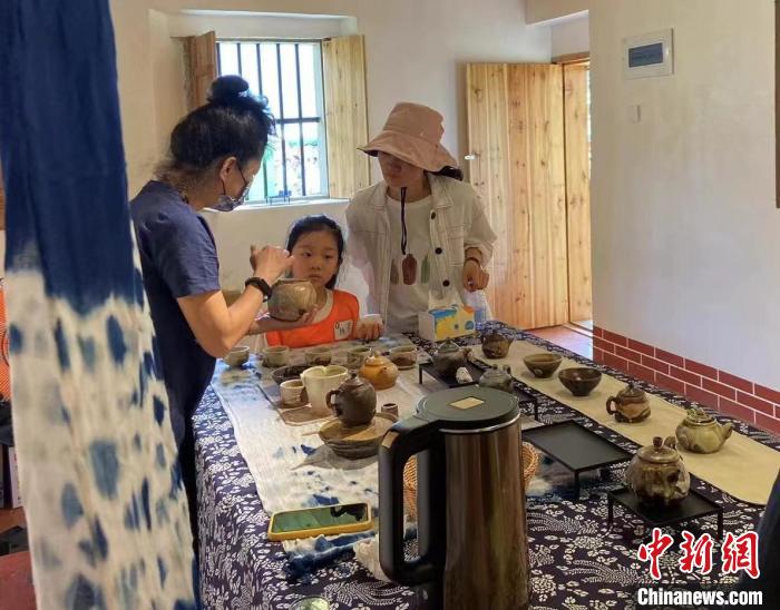 圖為：游客正在咨詢臺(tái)灣柴燒作品?！∪~秋云 攝