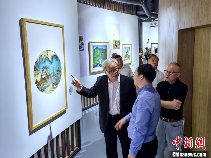 海峽兩岸藝術(shù)家畫展上，藝術(shù)家進(jìn)行藝術(shù)交流?！「毒窜?攝