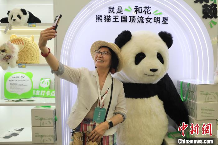 美國華視總裁楊蓮花與大熊貓文創(chuàng)產(chǎn)品合影?！⊥趵?攝