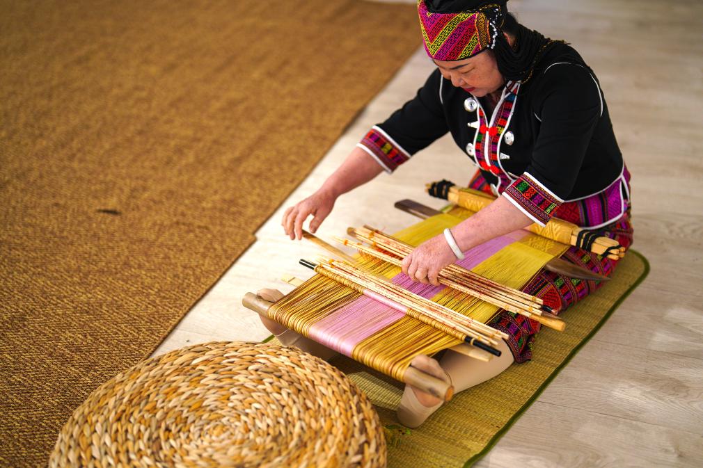 4月17日，黎族傳統(tǒng)紡染織繡技藝國(guó)家級(jí)代表性傳承人劉香蘭在2023年意大利米蘭設(shè)計(jì)周上展示黎錦織造技藝。新華社發(fā)