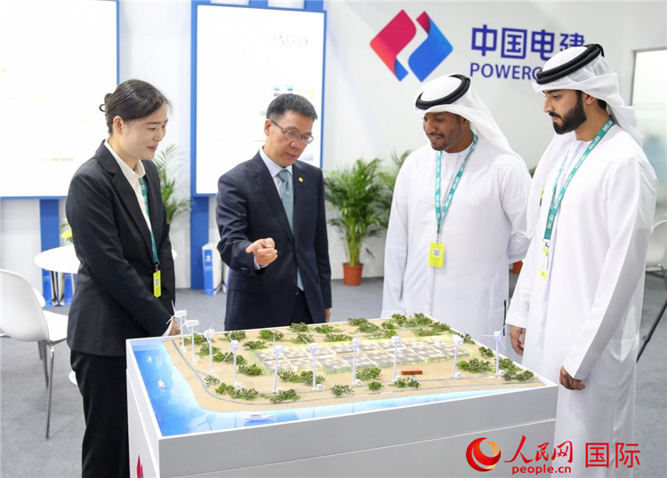訪客在中國電建展臺參觀風(fēng)電項目沙盤。人民網(wǎng) 塔里克·易卜拉欣攝