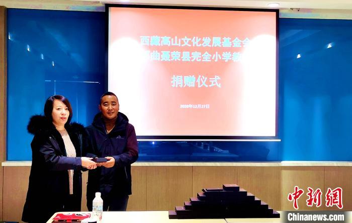 圖為西藏高山文化發(fā)展基金會(huì)理事長(zhǎng)溫麗向聶榮縣完全小學(xué)負(fù)責(zé)人捐助儀器。　于賓 攝