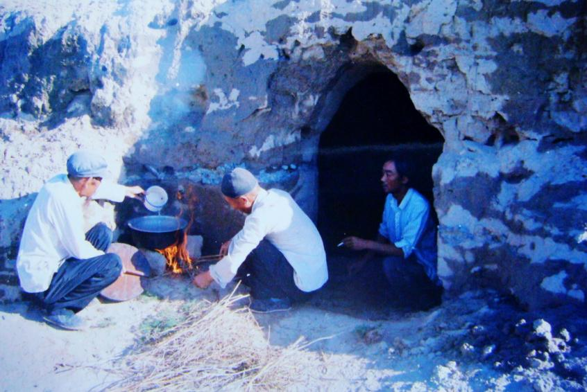1983年，“六老漢”一代治沙人在“地窩子”生活做飯。新華社發(fā)（八步沙林場供圖）