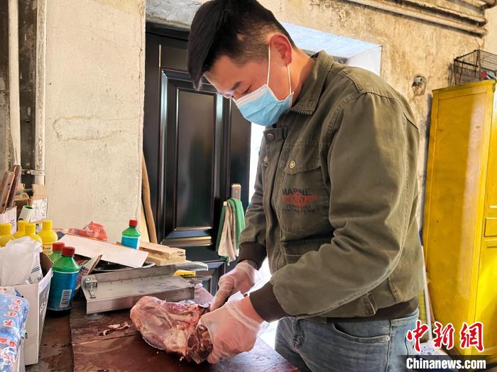 圖為雪豹“奶爸”史壽軍正在準備投喂雪豹的食材?！●R銘言 攝