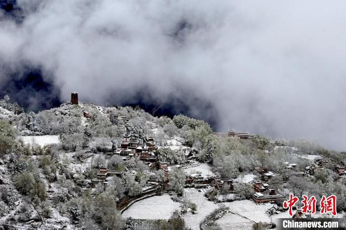 雪后的藏寨和碉樓構(gòu)成美麗的雪景?！〗党鯘衫?攝