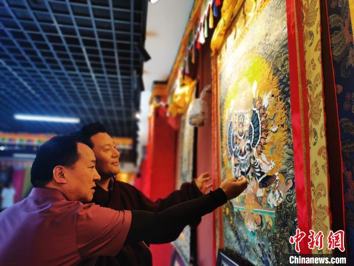 圖為久美尖措展示唐卡作品。　張?zhí)砀?攝