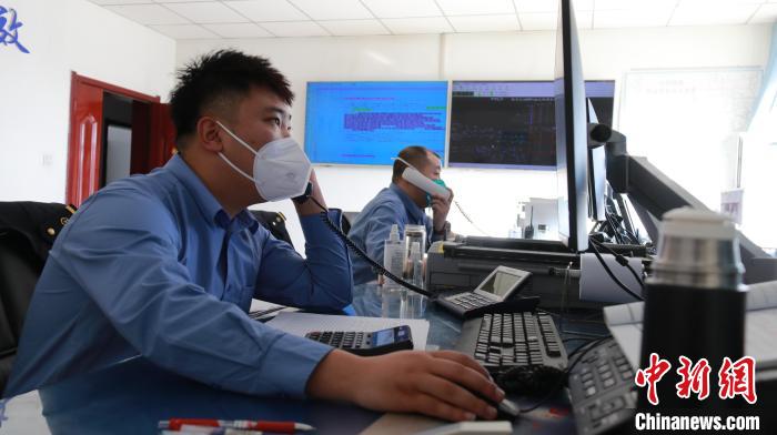 圖為貨運調(diào)度人員與外勤工作人員聯(lián)系掌握車輛裝載情況?！±钌?攝