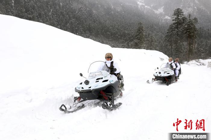 圖為雪地摩托車開路。　薛金博 攝