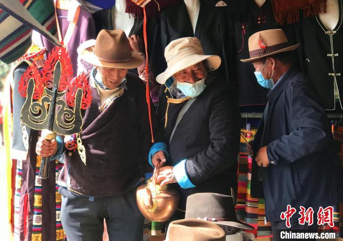 圖為三位藏族老人在集市上聊天交談?！∪轿木?攝