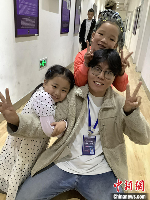 “Z世代”旦真旺加認為，拉薩是一座開放與包容的城市，記憶中的拉薩是彩色的。2021年，旦真旺加從浙江大學漢語言文學專業(yè)畢業(yè)后，他選擇回到拉薩，成為一名漢語文實習助教。圖為8月4日，旦真旺加在課間陪學生玩耍。 <a target='_blank' ><p  align=
