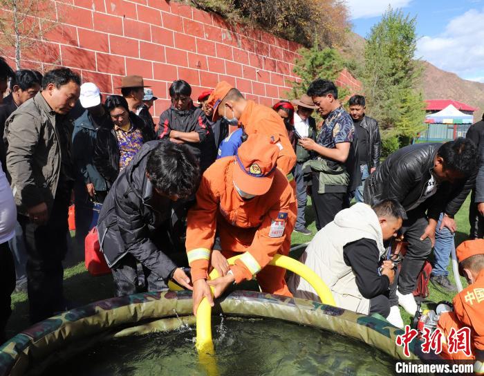 圖為森林消防員為護(hù)林員講解滅火裝備的使用方法。　昌都市森林消防支隊(duì) 供圖