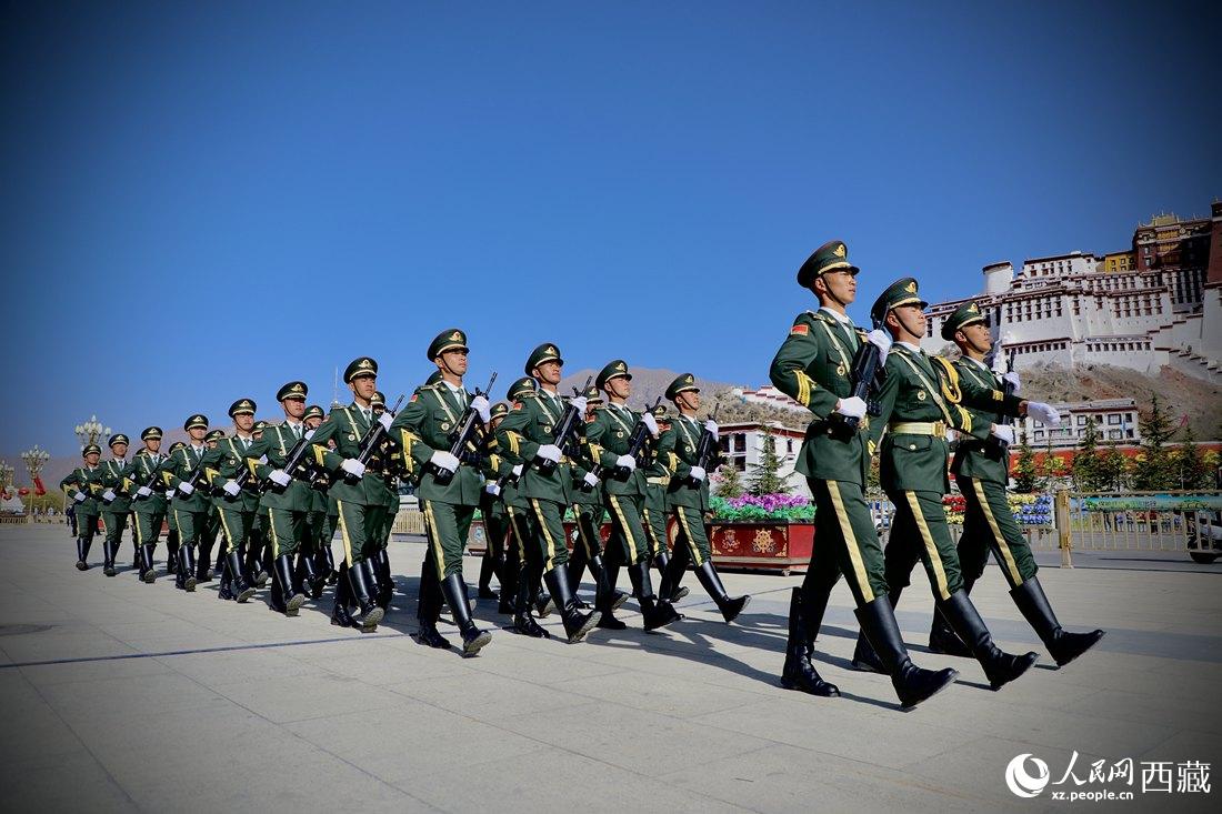 國旗護(hù)衛(wèi)隊隊員緊握鋼槍，踏著威武雄壯的步伐，走向國旗臺。人民網(wǎng) 次仁羅布攝