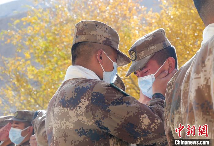 圖為什布奇邊防連退伍老兵與戰(zhàn)友相擁而泣，依依惜別。　徐昌成 攝