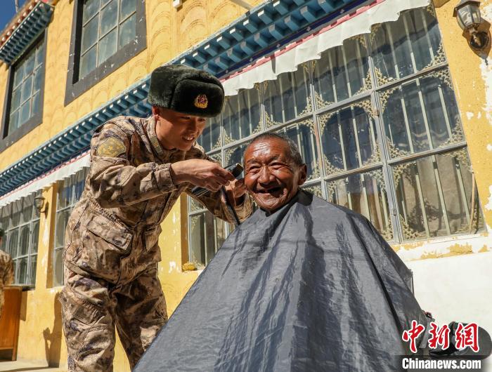 圖為阿里軍分區(qū)某邊防團(tuán)官兵為駐地群眾理發(fā)迎藏歷新年?！〉┰鰝愔?攝