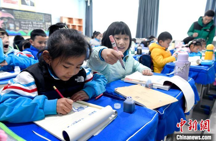 3月14日，西藏拉薩市第一小學(xué)一年級六班學(xué)生白瑪朗珍(圖左)在藏語文課上書寫藏文?！±盍?攝