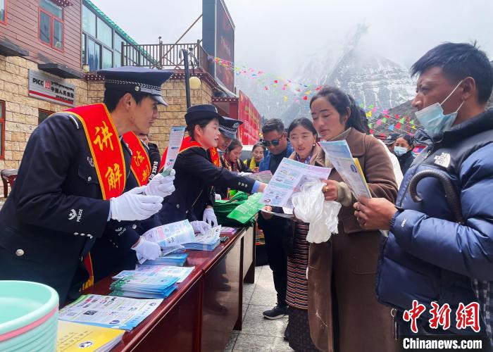 圖為山南玉麥邊境派出所民警為轄區(qū)群眾發(fā)放法律知識宣傳單?！＄婗?　攝