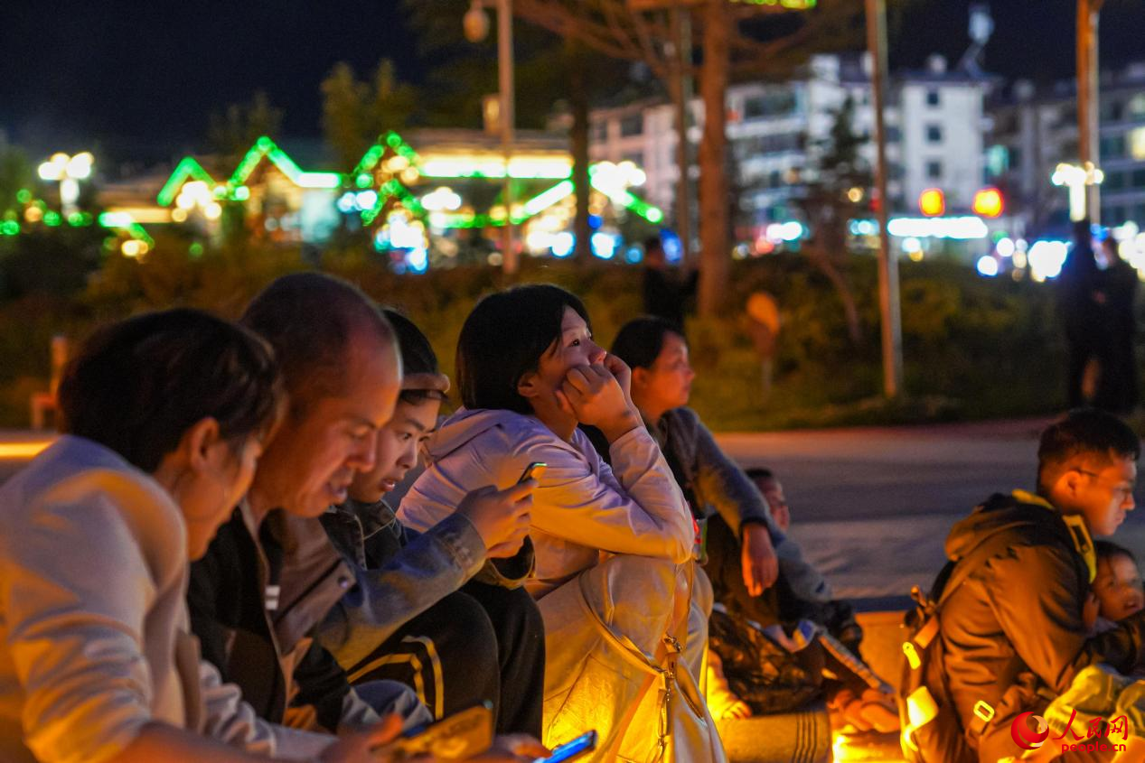 市民坐在西藏林芝市民族團(tuán)結(jié)廣場臺(tái)階上欣賞音樂噴泉。人民網(wǎng)記者 趙晨攝